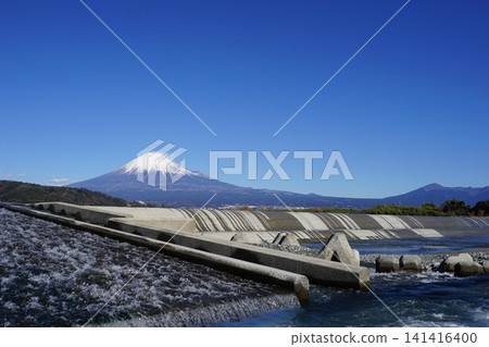 富士川和堰壩,遠方是白雪皚皚的富士山,天空湛藍晴朗。 2149年1月,富士山,富士川和堰壩 富士川和堰壩,遠方是白雪皚皚的富士山,天空湛藍晴朗。 2149年1月,富士山,富士川和堰壩 141416400