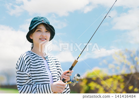 A young woman enjoying fishing as a hobby 141416484