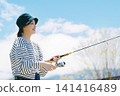 A young woman enjoying fishing as a hobby A young woman enjoying fishing as a hobby 141416489