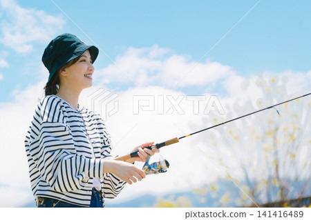 一位年輕女子以釣魚為嗜好。 一位年輕女子以釣魚為嗜好。 141416489