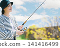 A young woman enjoying fishing as a hobby A young woman enjoying fishing as a hobby 141416499
