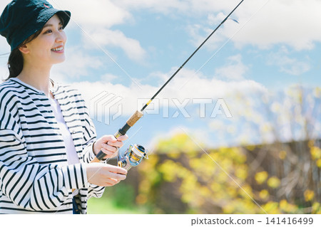 一位年輕女子以釣魚為嗜好。 一位年輕女子以釣魚為嗜好。 141416499