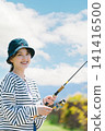 A young woman enjoying fishing as a hobby A young woman enjoying fishing as a hobby 141416500
