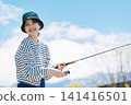 A young woman enjoying fishing as a hobby A young woman enjoying fishing as a hobby 141416501