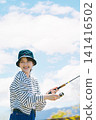 A young woman enjoying fishing as a hobby A young woman enjoying fishing as a hobby 141416502