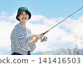 A young woman enjoying fishing as a hobby A young woman enjoying fishing as a hobby 141416503