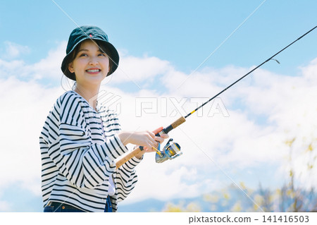 A young woman enjoying fishing as a hobby 141416503