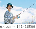 A young woman enjoying fishing as a hobby A young woman enjoying fishing as a hobby 141416509
