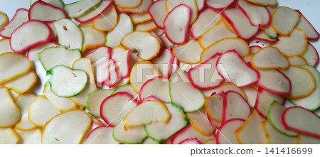 A flat lay arrangement of various types of colorful, uncooked Indonesian crackers. A flat lay arrangement of various types of colorful, uncooked Indonesian crackers. 141416699