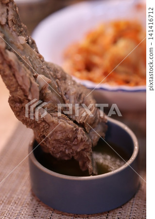 Meat Dipped in Sauce with Fried Snacks Close-Up 141416712