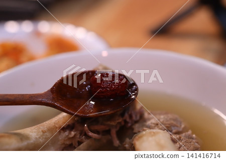 Spoon with Jujube Over Bone Soup Close-up Spoon with Jujube Over Bone Soup Close-up 141416714