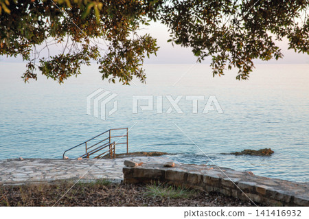 Seaside pier with and tree branch overhang in Istria, Croatia. Seaside pier with and tree branch overhang in Istria, Croatia. 141416932