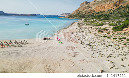 Aerial view of Balos lagoon with turquoise water and pink sand beach in Crete island Greece during sunny summer day with mountains and boat background Aerial view of Balos lagoon with turquoise water and pink sand beach in Crete island Greece during sunny summer day with mountains and boat background 141417231