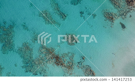Top down drone view of crystal clear turquoise sea water with underwater reef bottom at Elafonisi beach in Crete island Greece during summer background landscape Top down drone view of crystal clear turquoise sea water with underwater reef bottom at Elafonisi beach in Crete island Greece during summer background landscape 141417253
