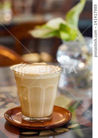 Warm latte coffee glass cup wooden saucer cozy cafe mood Warm latte coffee glass cup wooden saucer cozy cafe mood 141417989