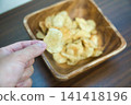 Potato chips served in a wooden bowl Potato chips served in a wooden bowl 141418196