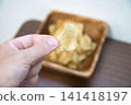 Potato chips served in a wooden bowl Potato chips served in a wooden bowl 141418197
