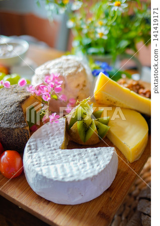 Artisan Cheese Assortment with Kiwi Fruit on Rustic Wooden Cheese Board Artisan Cheese Assortment with Kiwi Fruit on Rustic Wooden Cheese Board 141419171