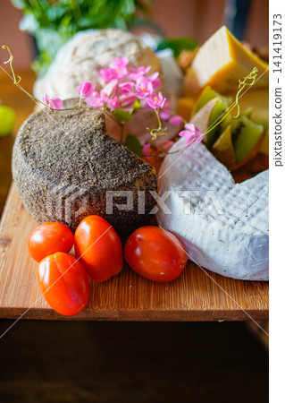 Rustic artisan cheese with fresh vegetables and fruits close up Rustic artisan cheese with fresh vegetables and fruits close up 141419173