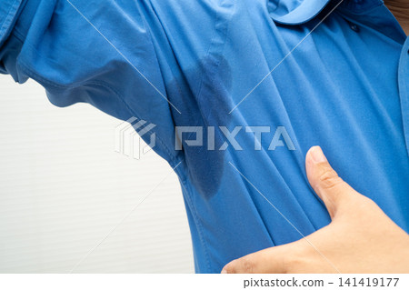Man with sweaty arm pit on shirt when working in office, Hyperhidrosis sweating. Man with sweaty arm pit on shirt when working in office, Hyperhidrosis sweating. 141419177
