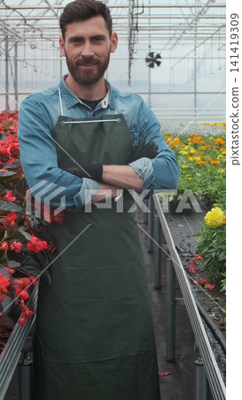 Vertical video Gardeners working at the greenhouse seedlings successfully puts. Vertical video Gardeners working at the greenhouse seedlings successfully puts. 141419309