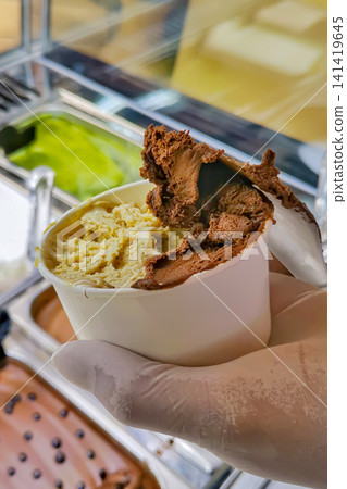 Chocolate and Pistachio Artisan Gelato Being Scooped into Serving Cup Chocolate and Pistachio Artisan Gelato Being Scooped into Serving Cup 141419645