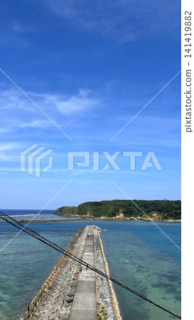 A breakwater stretches straight out into the emerald sea. A breakwater stretches straight out into the emerald sea. 141419882