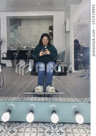 Woman sitting in chair at professional hair salon. UGC Woman sitting in chair at professional hair salon. UGC 141419993