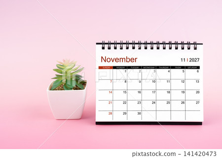 Novemober 2027, Monthly desk calendar for 2027 year on pink background. Novemober 2027, Monthly desk calendar for 2027 year on pink background. 141420473
