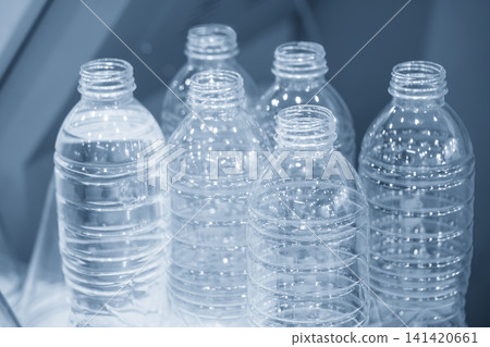 Close-up of a group of transparent plastic bottles for drinking water in a mass production process. Close-up of a group of transparent plastic bottles for drinking water in a mass production process. 141420661