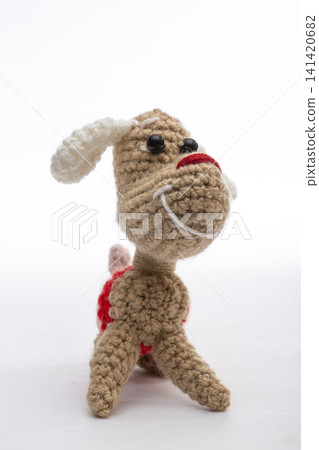 Knitted woolen dog on a white background Knitted woolen dog on a white background 141420682