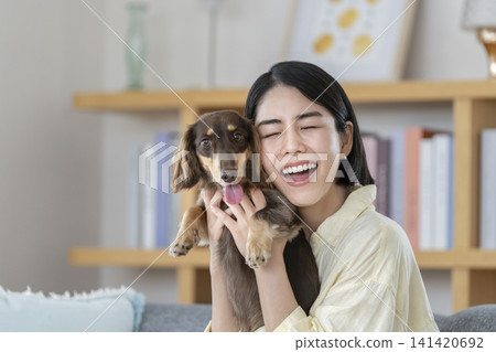 一位女主人輕撫她的狗。 141420692