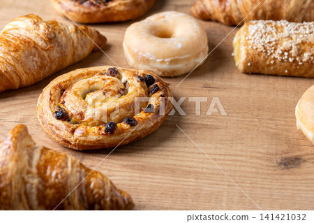 Assorted fresh pastries on wooden table Assorted fresh pastries on wooden table 141421032