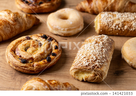 Assorted fresh pastries on wooden table Assorted fresh pastries on wooden table 141421033