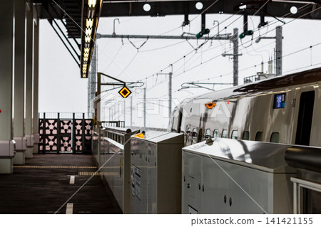 新幹線車站月台,安裝了月台屏蔽門,一列火車,以及飄雪的冬日景象。 新幹線車站月台,安裝了月台屏蔽門,一列火車,以及飄雪的冬日景象。 141421155