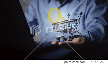 Businessman hand holding small shopping cart with 0 percent interest rate icon. Online shopping promotion, financing installment plan, and e-commerce marketing strategy on laptop background. Businessman hand holding small shopping cart with 0 percent interest rate icon. Online shopping promotion, financing installment plan, and e-commerce marketing strategy on laptop background. 141421268