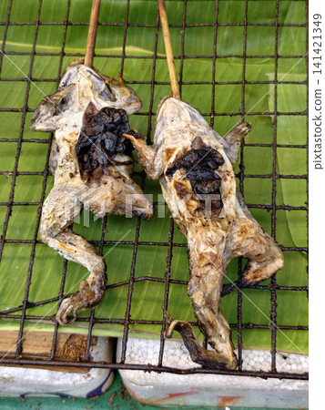 Traditional grilled frogs on bamboo skewers sold at street market Traditional grilled frogs on bamboo skewers sold at street market 141421349