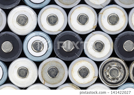 Top-Down Macro View of Multiple Used Alkaline Batteries Packed Together Showing Negative Terminals, Worn White and Black Casings, and Metal Contacts Top-Down Macro View of Multiple Used Alkaline Batteries Packed Together Showing Negative Terminals, Worn White and Black Casings, and Metal Contacts 141422027