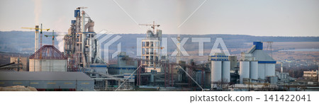 Cement plant with high factory structure and tower cranes at industrial production area. Manufacture, global industry and air pollution concept Cement plant with high factory structure and tower cranes at industrial production area. Manufacture, global industry and air pollution concept 141422041