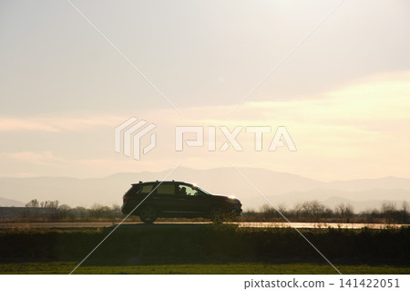 Car driving fast on intercity road at sunset. Highway traffic in evening 141422051