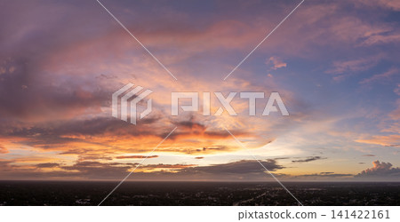 Amazing sunset skyscape. Evening sky with bright colorful orange and yellow clouds over dark landscape Amazing sunset skyscape. Evening sky with bright colorful orange and yellow clouds over dark landscape 141422161