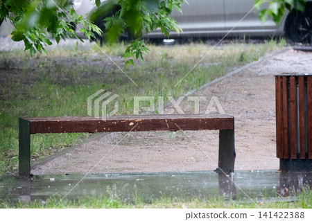 Heavy rain on a empty playground with a bench in summer.  141422388