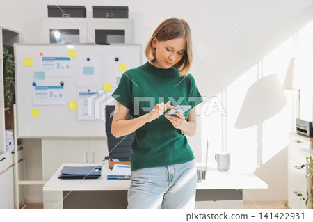 Closeup image of a businesswoman using mobile phone in office Closeup image of a businesswoman using mobile phone in office 141422931