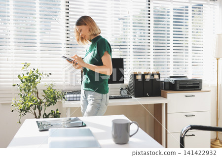 Closeup image of a businesswoman using mobile phone in office Closeup image of a businesswoman using mobile phone in office 141422932