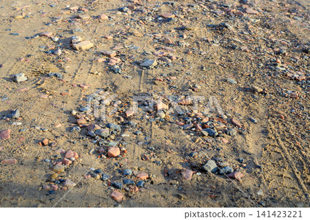 Rural sandy road with gravel and sand ground texture. Natural background of soil path with small pink granite pebbles, crushed stones, Rural sandy road with gravel and sand ground texture. Natural background of soil path with small pink granite pebbles, crushed stones, 141423221