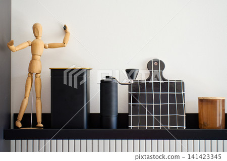 Manual coffee grinder stands on kitchen shelf with coffee accessories and storage container Manual coffee grinder stands on kitchen shelf with coffee accessories and storage container 141423345
