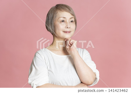 Portrait of a senior woman on a pink background. Portrait of a senior woman on a pink background. 141423462