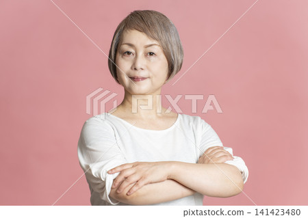 Portrait of a senior woman on a pink background. 141423480