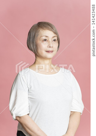 Portrait of a senior woman on a pink background. 141423488