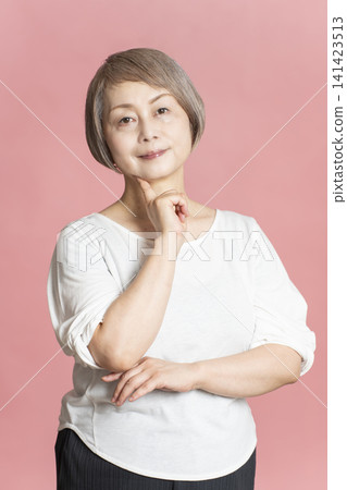 Portrait of a senior woman on a pink background. Portrait of a senior woman on a pink background. 141423513